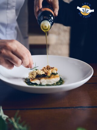 Arrangement of a fish on the plate with olive oil