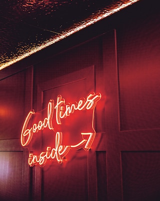Insegna luminosa con la scritta "Good times inside".