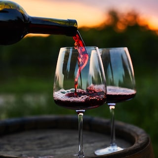 Wine is being poured into two wine glasses