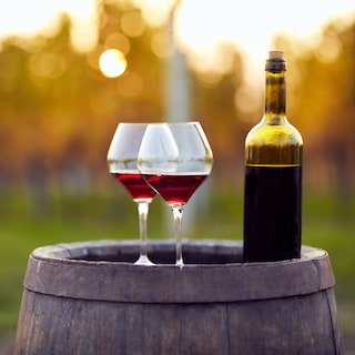 Two Wine glasses and a bottle of wine on a barrel