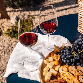 Glasses of red wine with a plate full of snacks