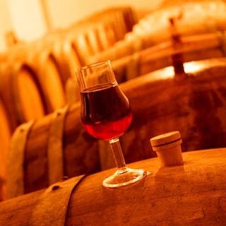 Glass of wine standing on a barrel