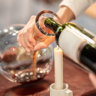 Wine is being poured into a carafe