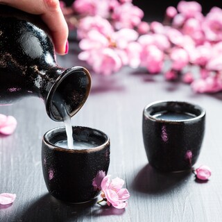 Sake is poured into guinomi