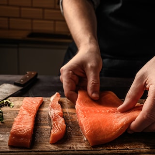 A chef is filetting salmon